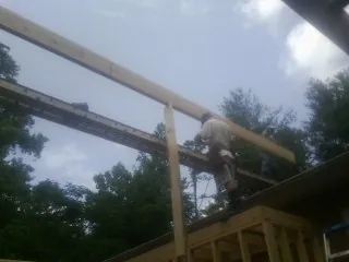 Carpenter setting a ridge beam over a new addition frame — Ice Dam Removal by Roofing Brothers in Morral