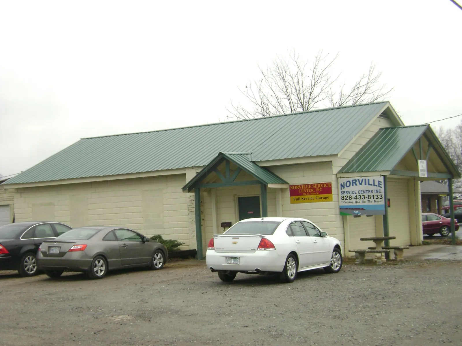 Green metal roof on a service garage with a covered entry in Morral