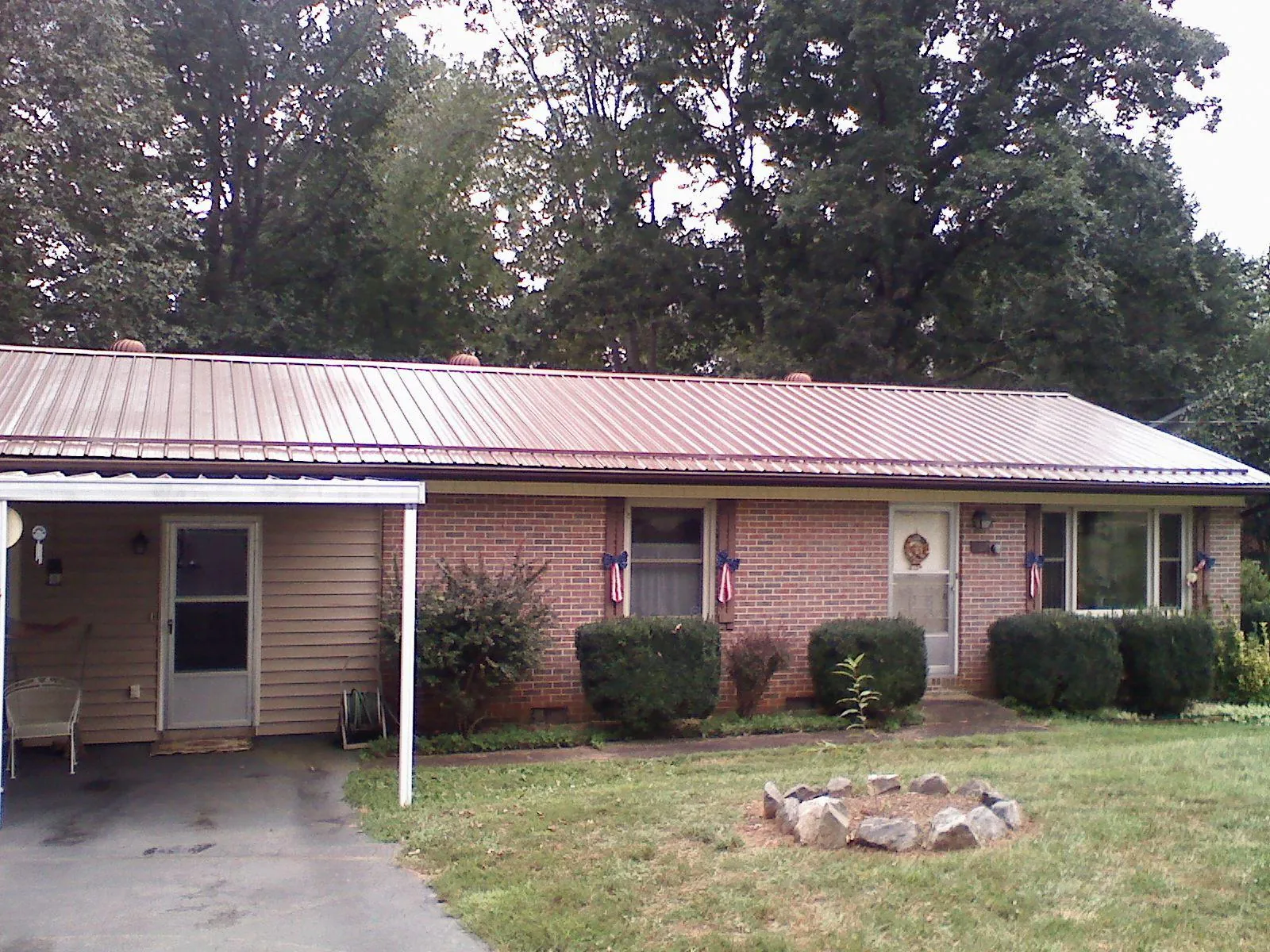 Bronze metal roof and carport on a brick ranch home — Roof Repair work by our crew in Morral